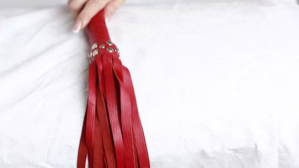 女の子は赤い革鞭を取ります。大人のおもちゃ. — ストック動画