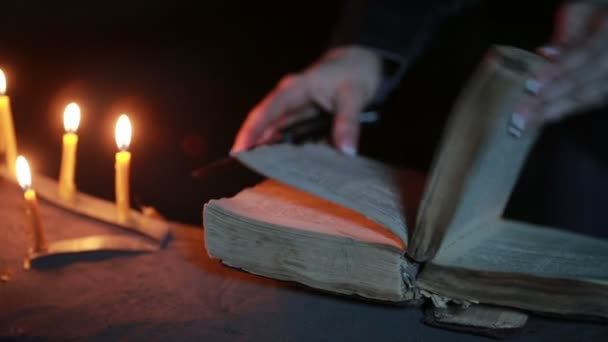 Bruxa segurando o ritual mágico. velho livro e vela. Dia das Bruxas — Vídeo de Stock