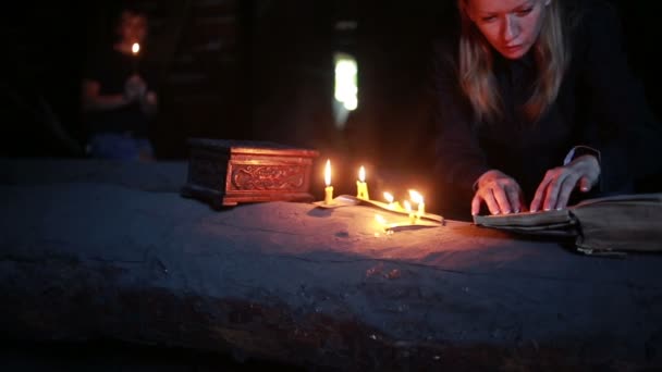 Hexe mit dem magischen Ritual. altes Buch und Kerze. halloween — Stockvideo