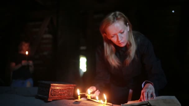 Bruja sosteniendo el ritual mágico. viejo libro y vela. Halloween. — Vídeos de Stock