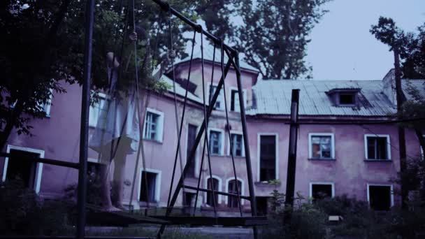 Il fantasma di una ragazzina su un'altalena nella vecchia casa in rovina. spirito maligno — Video Stock