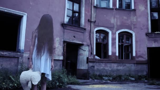 Espírito de uma menina com cabelos longos perto da velha mansão. Fantasma bebé — Vídeo de Stock