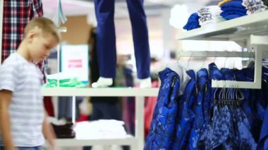 Sevimli gülümseyen çocuk giyim ve seçme duruyor