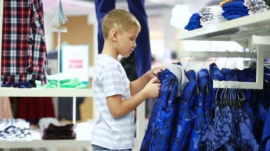 Sevimli gülümseyen çocuk giyim ve seçme duruyor