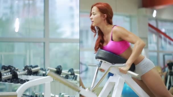 Beautiful girl trains in the gym. — Stock Video