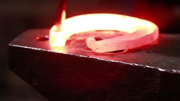 Le forgeron dans une forge forge un fer à cheval 