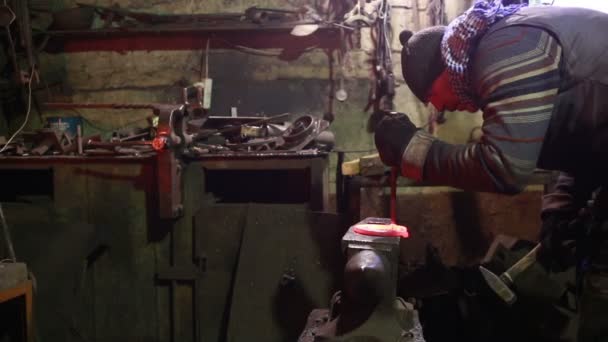 The smith in a smithy forges a horseshoe — Stock Video