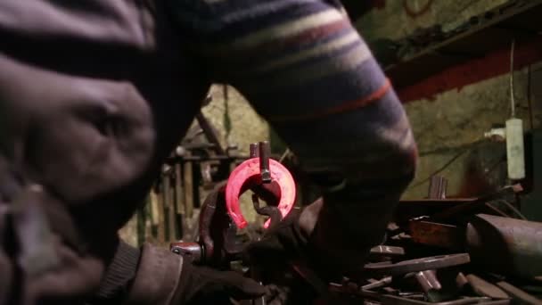 O ferreiro em um ferreiro forja uma ferradura — Vídeo de Stock