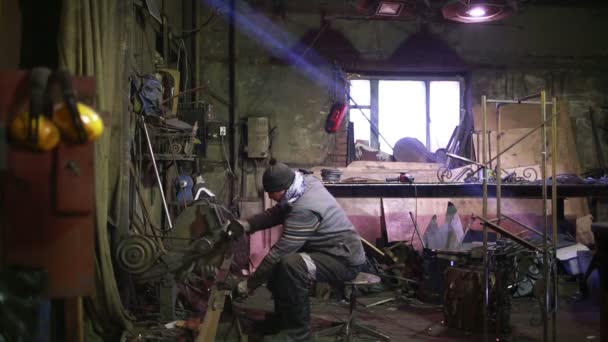 Ремесленник распиливает металл с дисковым шлифовальным станком в мастерской . — стоковое видео