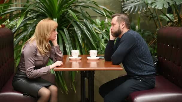 Man en vrouw in een café. koffie drinken. een zakelijke bijeenkomst — Stockvideo