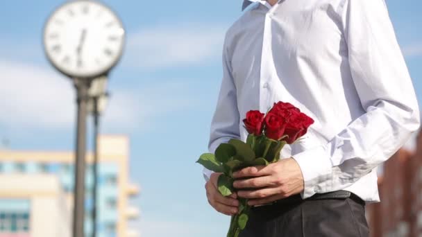 Pár setkání v den, mladý muž dává červené růže se svou krásnou přítelkyní — Stock video