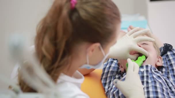 Niño pequeño durante la inspección de la cavidad oral. dentista — Vídeos de Stock