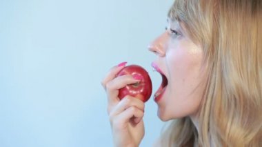 güzel kız bir mavi bir Kırmızı elma yiyor