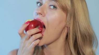 güzel kız bir mavi bir Kırmızı elma yiyor