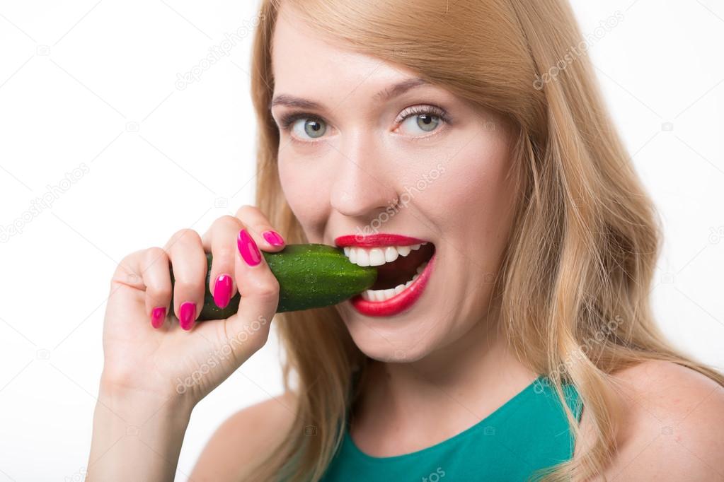 Young woman eating cucumber. Stock Photo by ©kopitin 115372952