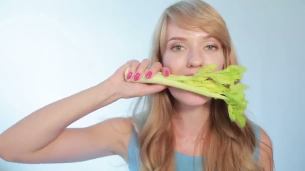 Mooie jonge vrouw een stok van selderij eten — Stockvideo