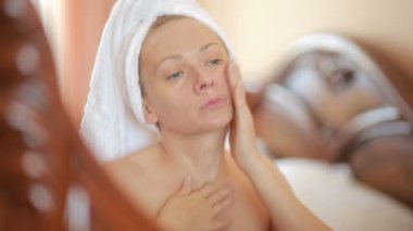 Uygulama kadın nemlendirici cilt kremi aynaya bakmak yüzünde maske.