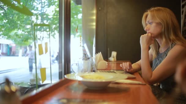 Mujer trabajando en la computadora portátil moderna en la cafetería — Vídeo de stock