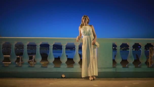 Дівчина в довгій білій сукні. прогулянки вздовж пляжу вночі . — стокове відео