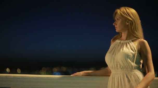 Menina em um vestido branco longo. caminhadas ao longo da praia à noite . — Vídeo de Stock