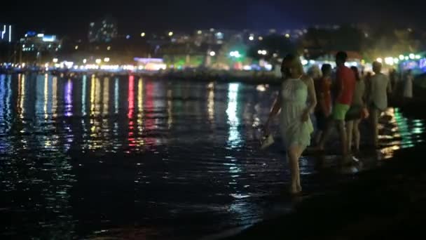 Ragazza in un lungo vestito bianco. passeggiate lungo la spiaggia di notte . — Video Stock