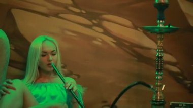 Durağındayım kadın nargile teneffüs edilmesi. Kız sigara shisha Cafe Divan yalan.