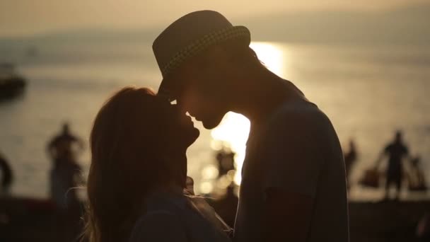 Couple silhouetté se tiennent et s'embrassent sur la plage. date sur le front de mer — Video