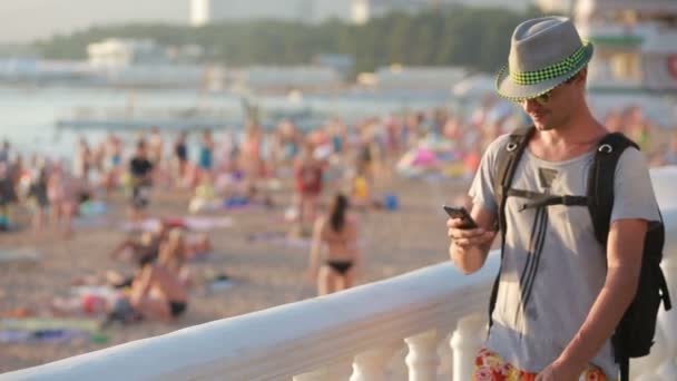 Hombre usando el teléfono inteligente junto al mar. fotografiado en un teléfono — Vídeos de Stock