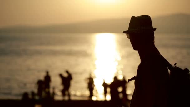 Jeune homme heureux utilisant un smartphone au bord de la mer. promenades touristiques le long de la promenade — Video