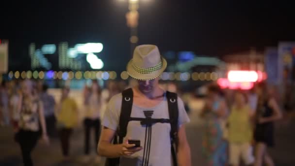 Hombre usando un teléfono móvil en la calle. un hombre guapo en un sombrero con smatrtfonom — Vídeo de stock