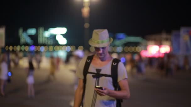 Um homem a usar um telemóvel na rua. um homem bonito de chapéu com smatrtfonom — Vídeo de Stock