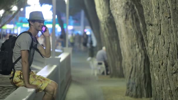 Людина використовує мобільний телефон на вулиці. красивий чоловік в капелюсі зі сморттоном — стокове відео