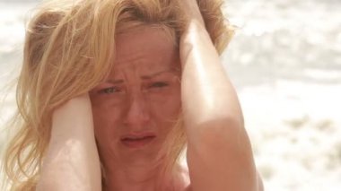 Sahilde Fırtına sırasında ağlayan üzgün kadın. rüzgarda çırpınan saç