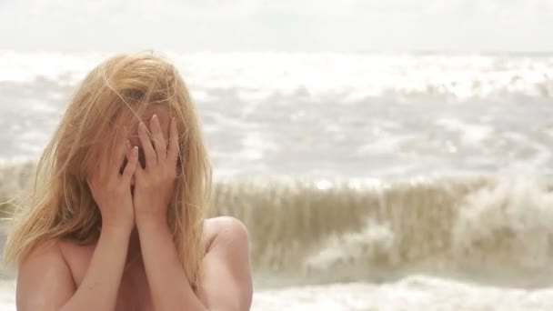 Donna triste che piange durante la tempesta sulla spiaggia. capelli svolazzanti nel vento — Video Stock