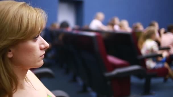 Mujer sentada en una presentación en el teatro. vacaciones escolares . — Vídeo de stock