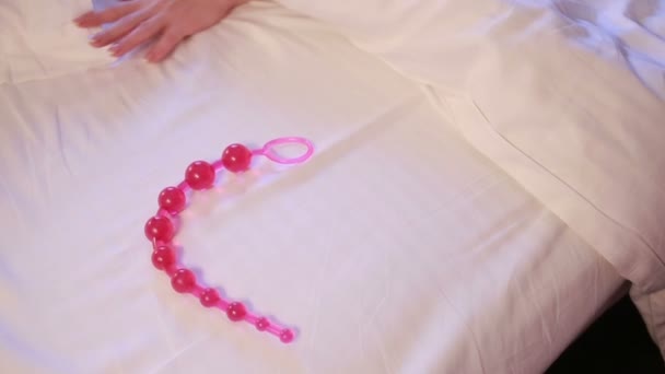 Womans hand reaching for dildo in bed. girl with a sex toy — Stockvideo