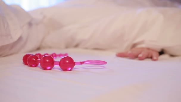 Womans hand reaching for dildo in bed. girl with a sex toy — Stockvideo