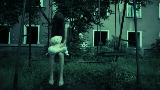 Küçük bir kız eski yıkık evinde bir salıncak üzerinde hayalet. kötü ruh — Stok video