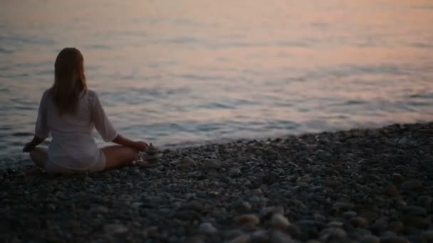 Joven practicando yoga en la playa al atardecer. mar tranquilo — Vídeos de Stock