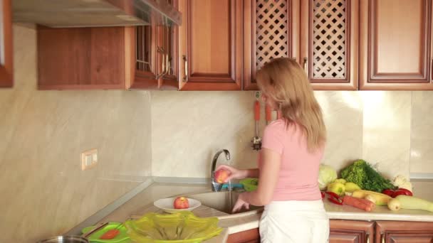 Girl washes peaches. vegetables on the kitchen table — Stock Video