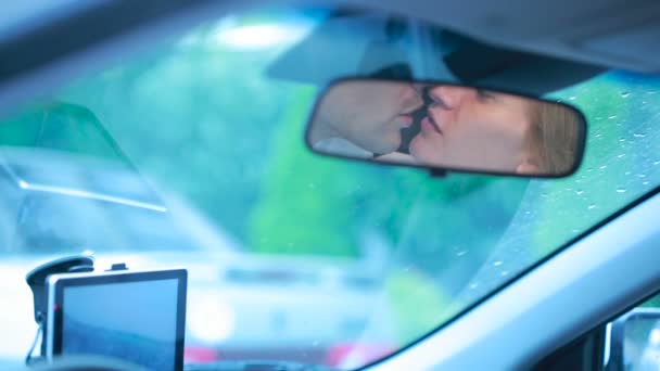 Paar kussen, weerspiegeld in de spiegel van de auto. liefhebbers van mannelijke en vrouwelijke — Stockvideo