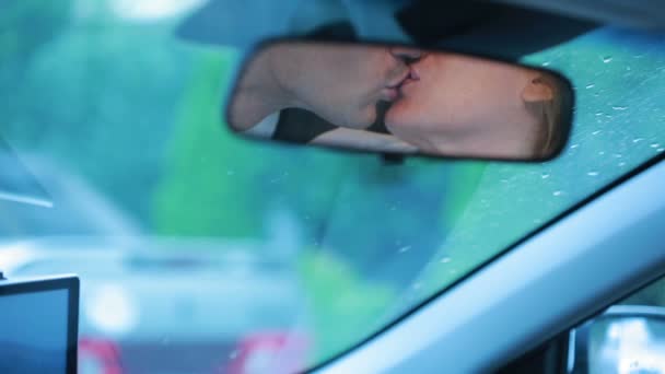 Couple kisses, reflected in the car mirror. male and female lovers — Stock Video