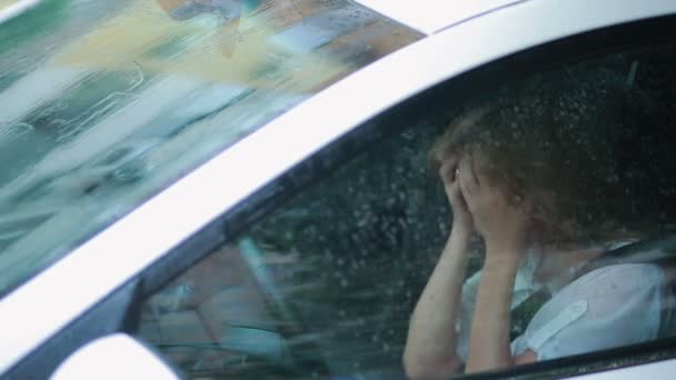 Triste fille pleurant dans la voiture. pluie dans la rue. femme hystérique — Video