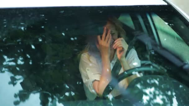 Sad girl crying in the car. rain on the street. woman in hysterics — Stock Video