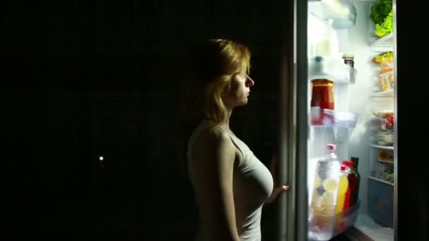 Femme ouvre le réfrigérateur la nuit. faim nocturne. régime alimentaire. gourmandise — Video