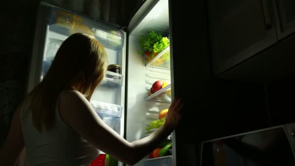 A mulher abre o frigorífico à noite. fome nocturna. dieta. glutonaria — Vídeo de Stock