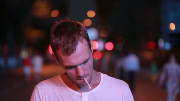 Man smokes a cigarette on the street at night. night city — Stock Video