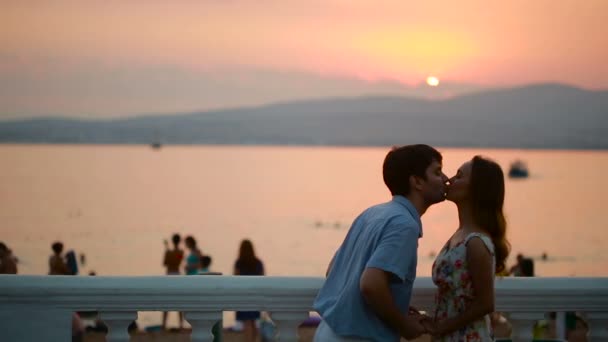 サンセットのロマンチックなカップルのシルエット。海の背景。男と女のキス — ストック動画