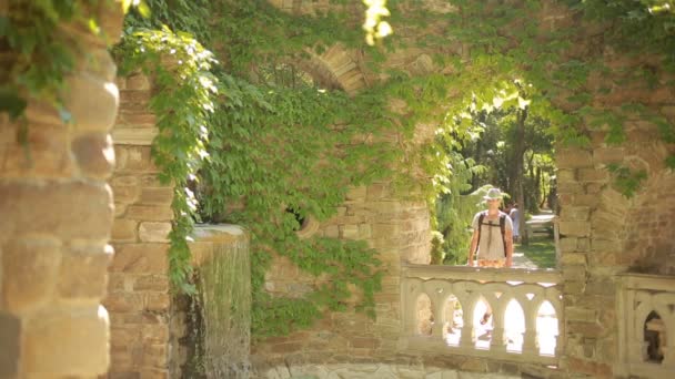 Молодой человек турист наблюдает за достопримечательностями. старинное здание с фонтаном — стоковое видео