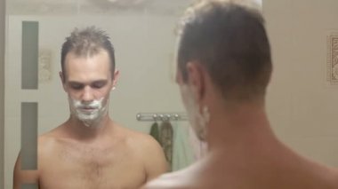 Adam yüzünü tıraş. yakışıklı adam banyoda tıraş.